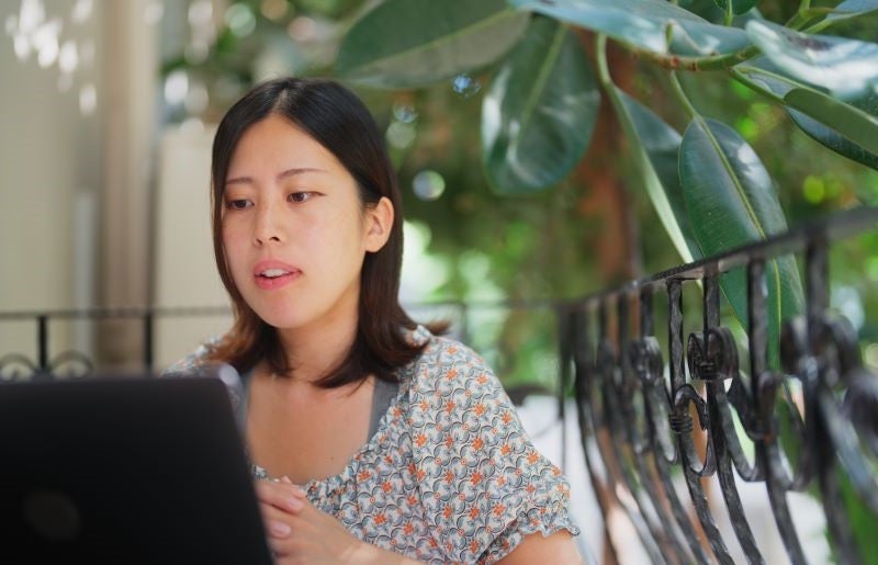 Woman working on laptop outdoors