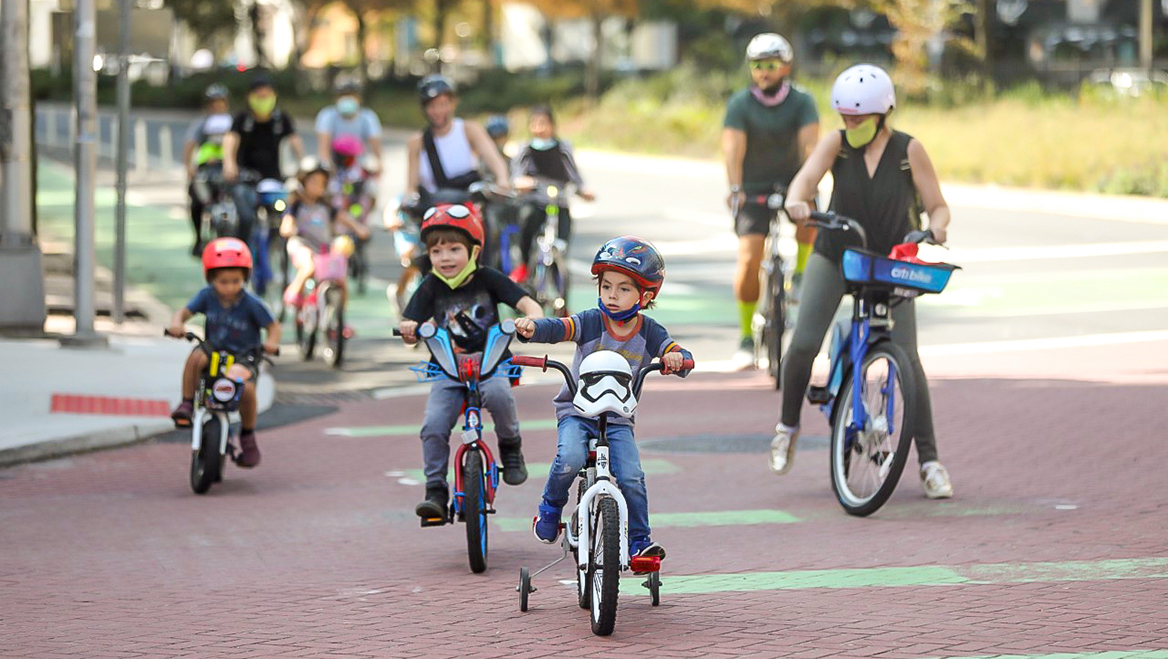 بزرگسالان و کودکان در بیرون دوچرخه سواری می کنند