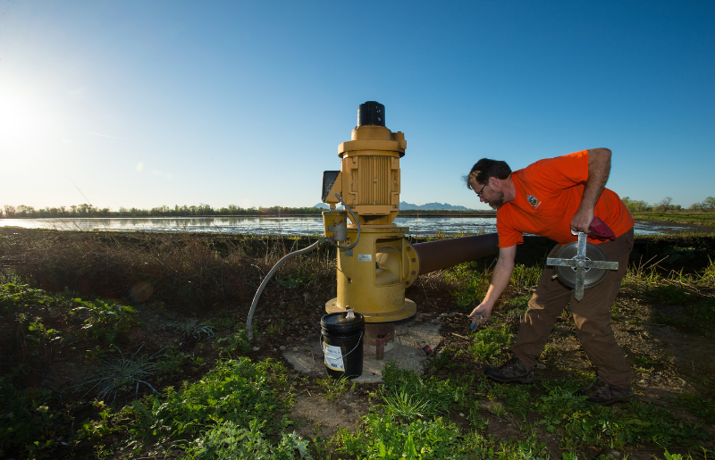 A state geologist measures water levels at an agricultural well in California's Central Valley. Credit: Kelly M. Grow/Department of Water Resources.