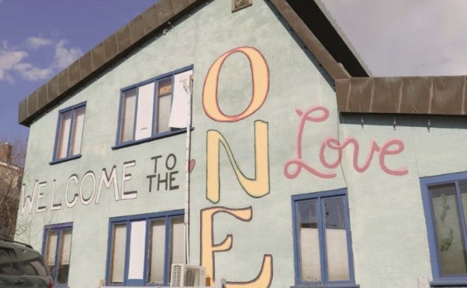 A building painted with the phrase 'Welcome to the ONE Love'