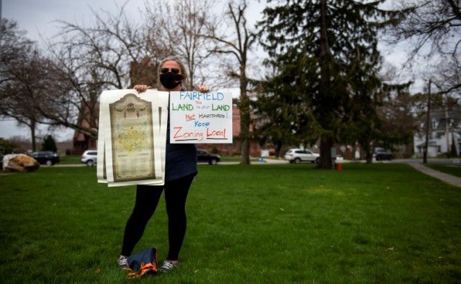 A Connecticut resident at a 2021 protest holds a sign urging lawmakers to "keep zoning local"