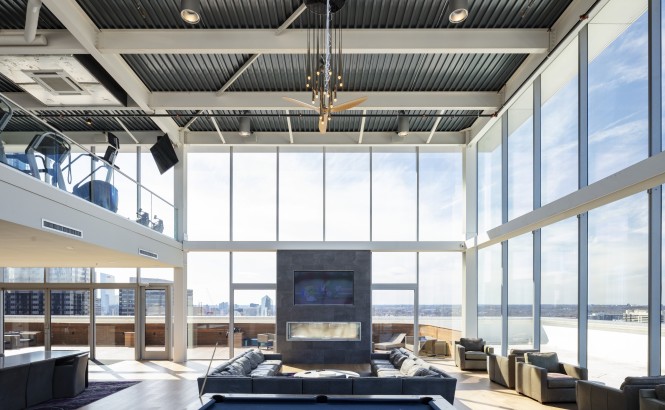 Residential common space in a former office building with floor-to-ceiling glass windows