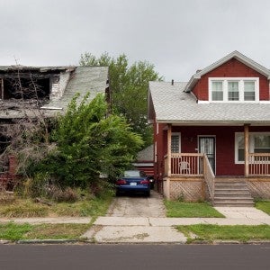 Two houses side by side, one abandoned, and the other well-kept