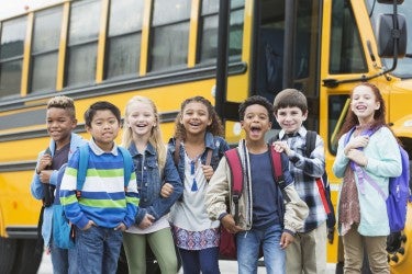 Elementary school children waiting outside bus Elementary school children waiting outside bus