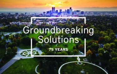 A park is in the foreground and tall buildings are visible furher out on the horizon. Text, overlaid on the photo, reads, groundbreaking solutions, 75 years.