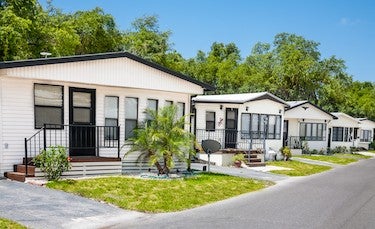 Row of manufactured homes A row of manufactured homes with front gardens in a sunny bright location.