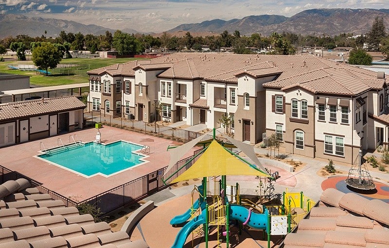 Arrowhead Grove in San Bernardino, CA This image shows a playground, pool, and houses that are part of the Arrowhead Grove Neighborhood Revitalization Plan. Mountains and green space are visible in the background.