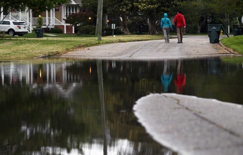 Credit: Aileen Devlin/Virginia Sea Grant via Flickr Two people walk on a flooded road