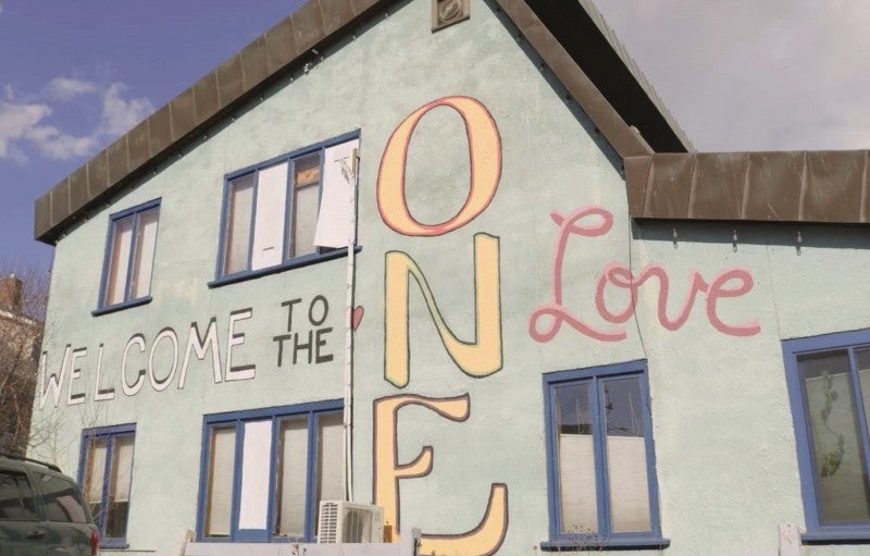 A building painted with the phrase 'Welcome to the ONE Love'