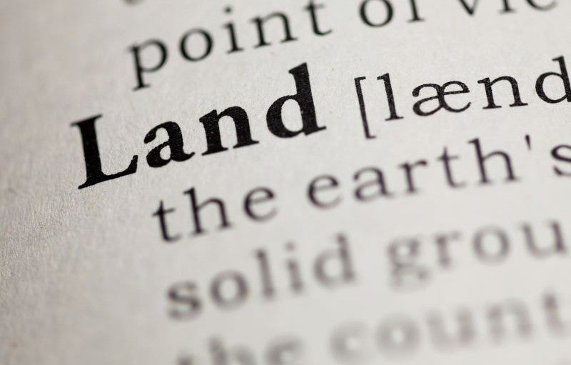Credit: Devonyu via iStock/ Getty Images Plus. Partial definition of the word land on a dictionary page