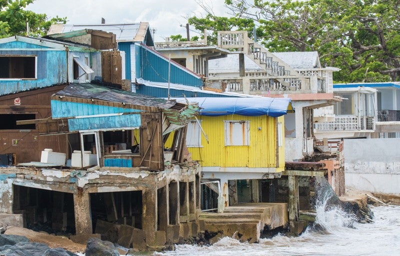 The west coast town of Rincón sustained heavy damage in Hurricane Maria. Credit: cestes001 (iStock/Getty Images Plus) Photograph shows small turquoise, yellow, and white buildings situated directly over water on a coastline in Rincón, Puerto Rico. Rough waters are visible. Rincón sustained heavy damage in Hurricane Maria. Credit: cestes001 (iStock/Getty Images Plus)