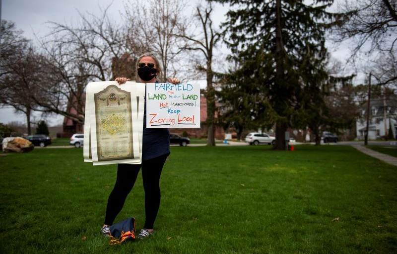 A Connecticut resident at a 2021 protest holds a sign urging lawmakers to "keep zoning local"