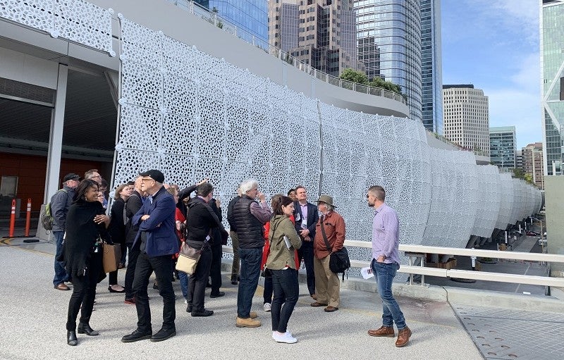 San Francisco Planning Director John Rahaim led a tour of the Transbay Transit Center at the 2019 American Planning Association annual conference. A group of city planners stands outside of the Transbay Transit Center in San Francisco.