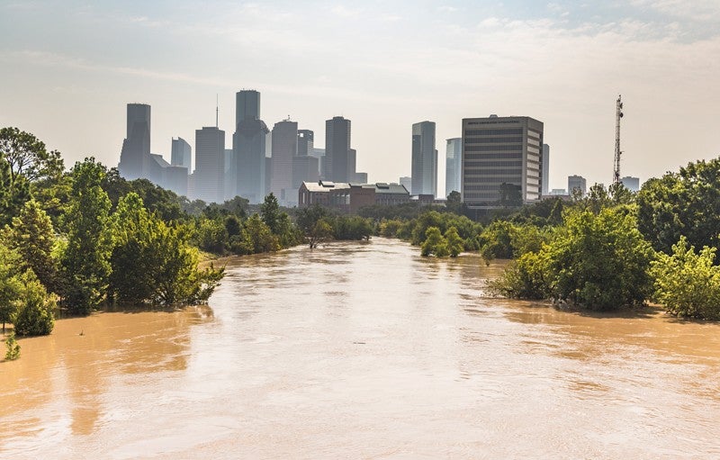 Brown flood water with the city of Houston in the background