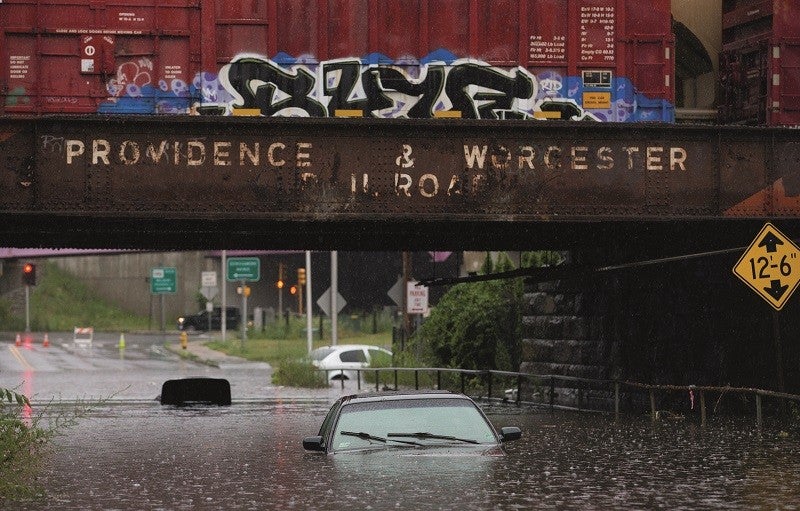 A car sits submerged under water as a results of heavy flooding. The car sits under an aging Providence & Worcester Railroad bridge in Worcester. 