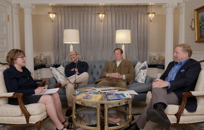 Four people sit in chairs in a room