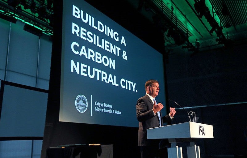 El alcalde de Boston, Marty Walsh, habla en los premios anuales Greenovate, que reconocen a los líderes del clima y la sostenibilidad en la comunidad. Crédito: John Wilcox, cortesía de la Alcaldía de la Ciudad de Boston. El alcalde de Boston, Martin Walsh, se presenta en el contexto de una presentación de powerpoint en un podio hablando con una multitud en los premios anuales Greenovate.