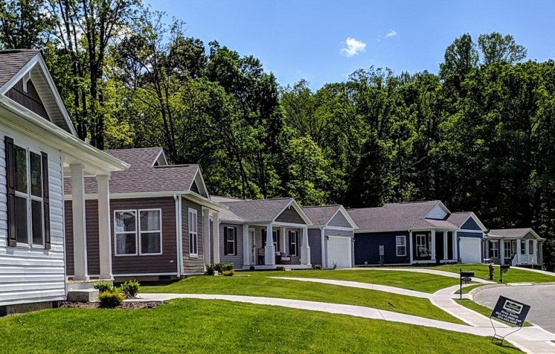 A row of manufactured homes with tidy lawns