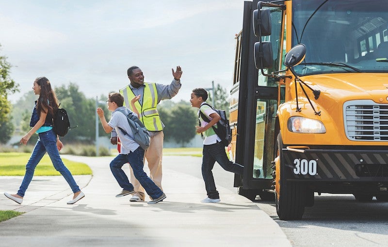Children departing a yellow school bus. Image: Children departing a yellow school bus.