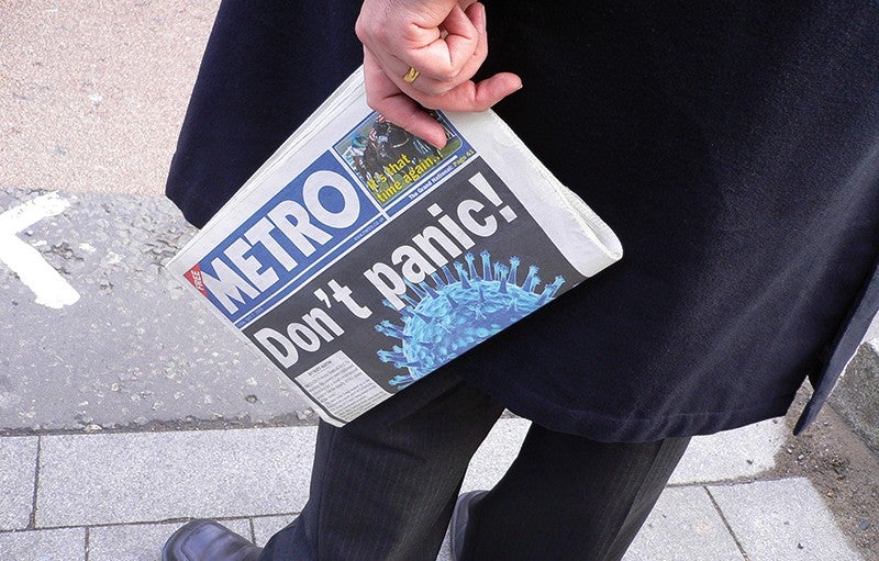 When it comes to inspiring change, scenario planning can be a more effective route than focusing on potential disasters. Credit: Jon Nicholls/Flickr CC BY 2.0. Photograph shows a man from the middle down, standing on a sidewalk, wearing a dark coat and pants, and holding a Metro newspaper in one hand. The headline on the newspaper is "Don't panic!"