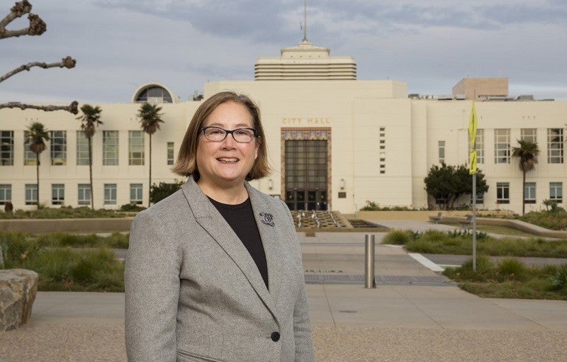 Santa Monica Mayor, Gleam Davis. Credit: Kristina Sado. Gleam Davis, the mayor of Santa Monica, stands at the forefront of the image. The city's city hall sits in the backrgound.