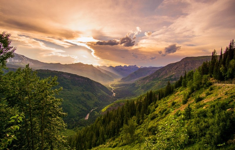 A landscape image from Montana showing green rolling hills and a winding river. 