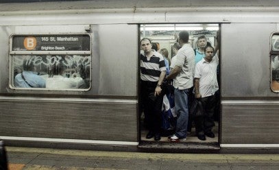 A  crowded subway car with open doors.