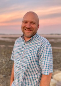 A hedshot of Jon Gorey with a sunset background by the ocean
