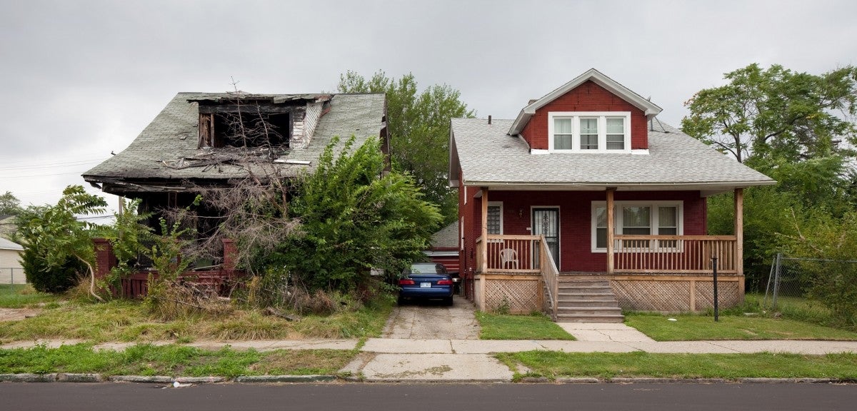 Two houses side by side, one abandoned, and the other well-kept