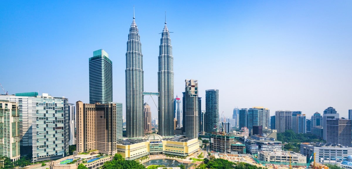 Kuala Lumpur, Malaysia An urban skyline with trees in the foreground