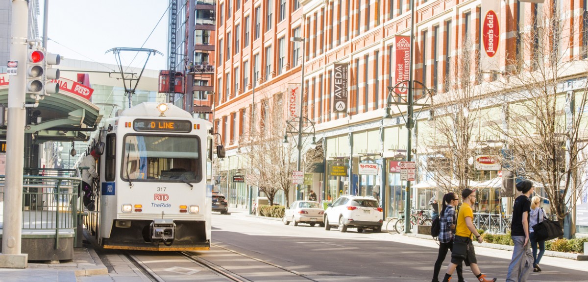 Downtown Denver, Colorado. Shown are a light rail train and a few pedestrians crossing the street.