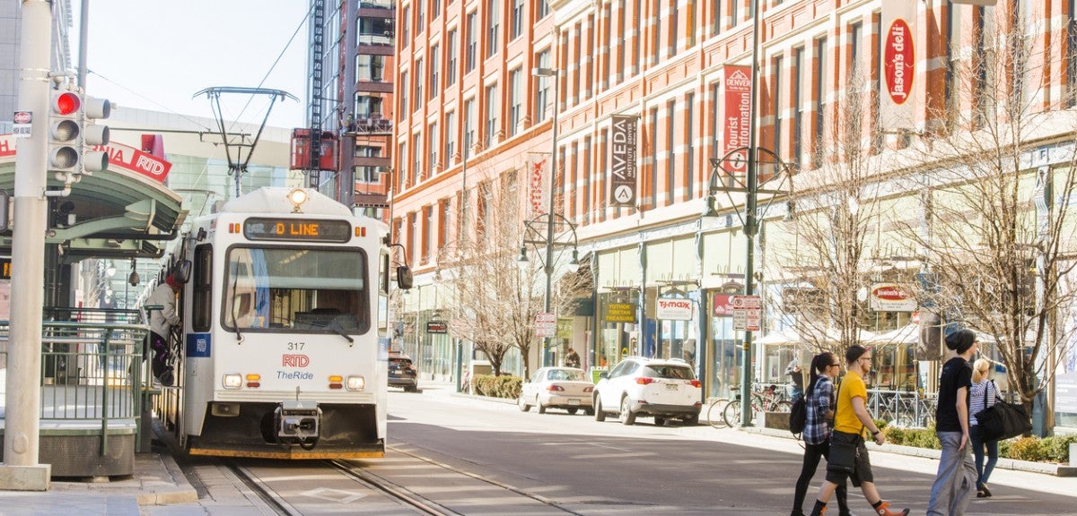 Denver, site of the November 2017 kickoff of the Consortium for Scenario Planning Downtown Denver, Colorado. Shown are a light rail train and a few pedestrians crossing the street.