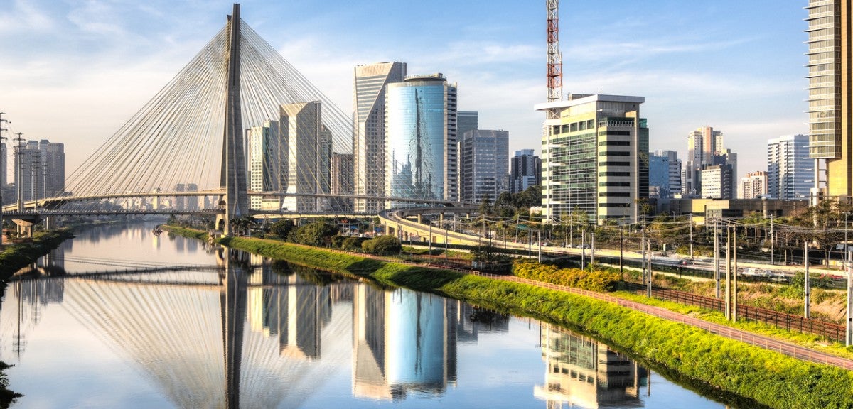 São Paulo, Brazil, a city that has deployed innovative forms of land value capture. A view of a river and a large bridge with an urban skyline in the background